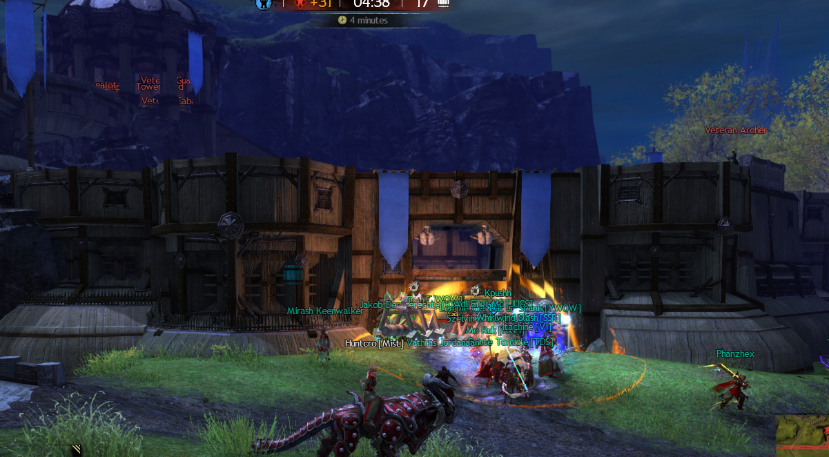 WvW players attacking a tower gate with battering rams